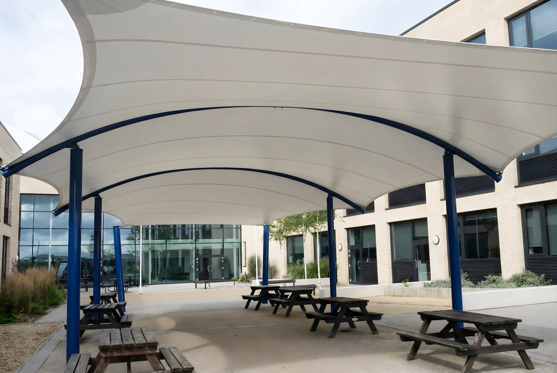 Skulptural segelinstallation som sol- och regnskydd för kommersiell fastighet