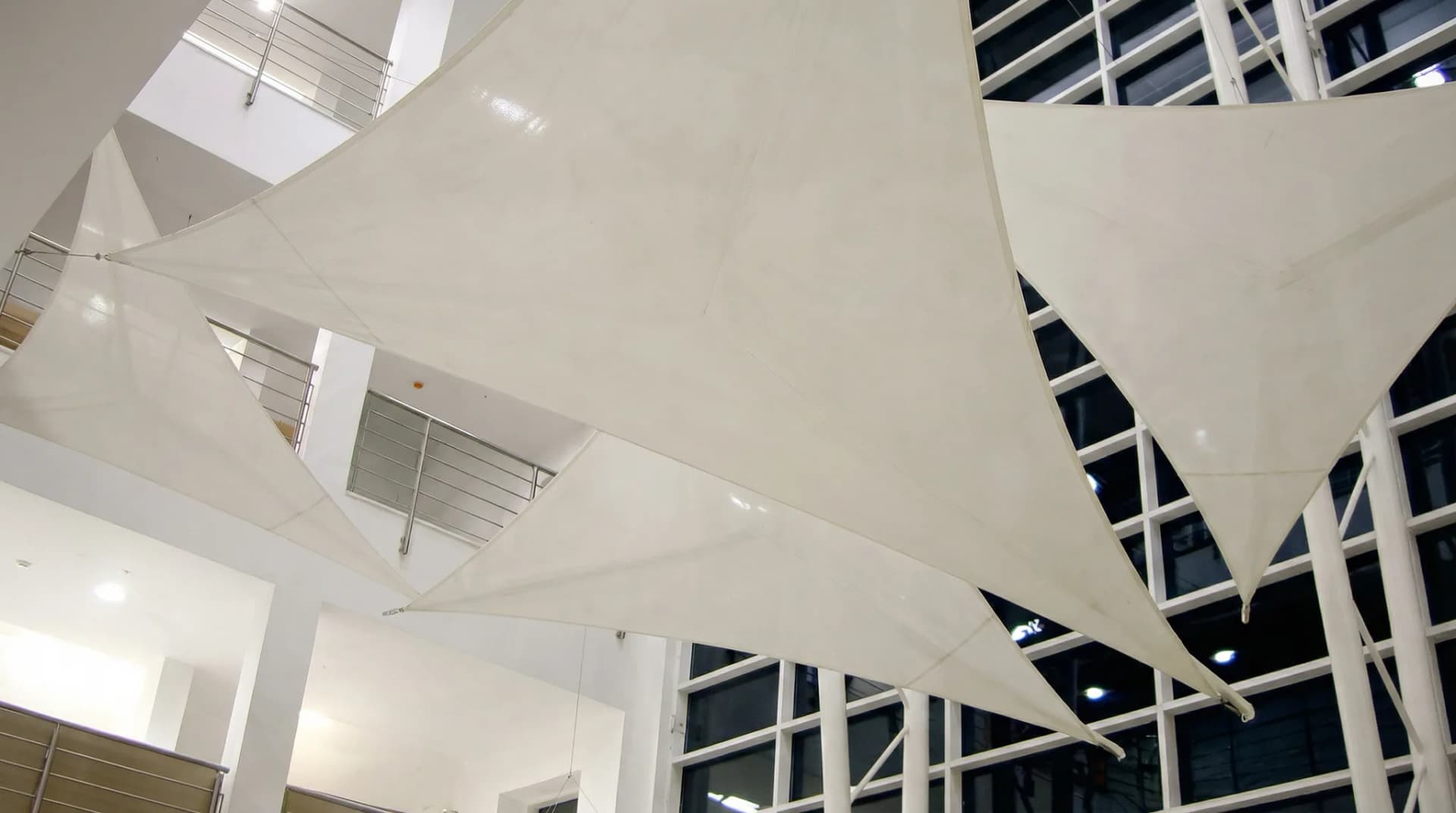 Invändigt solsegel under glastak i modern byggnad