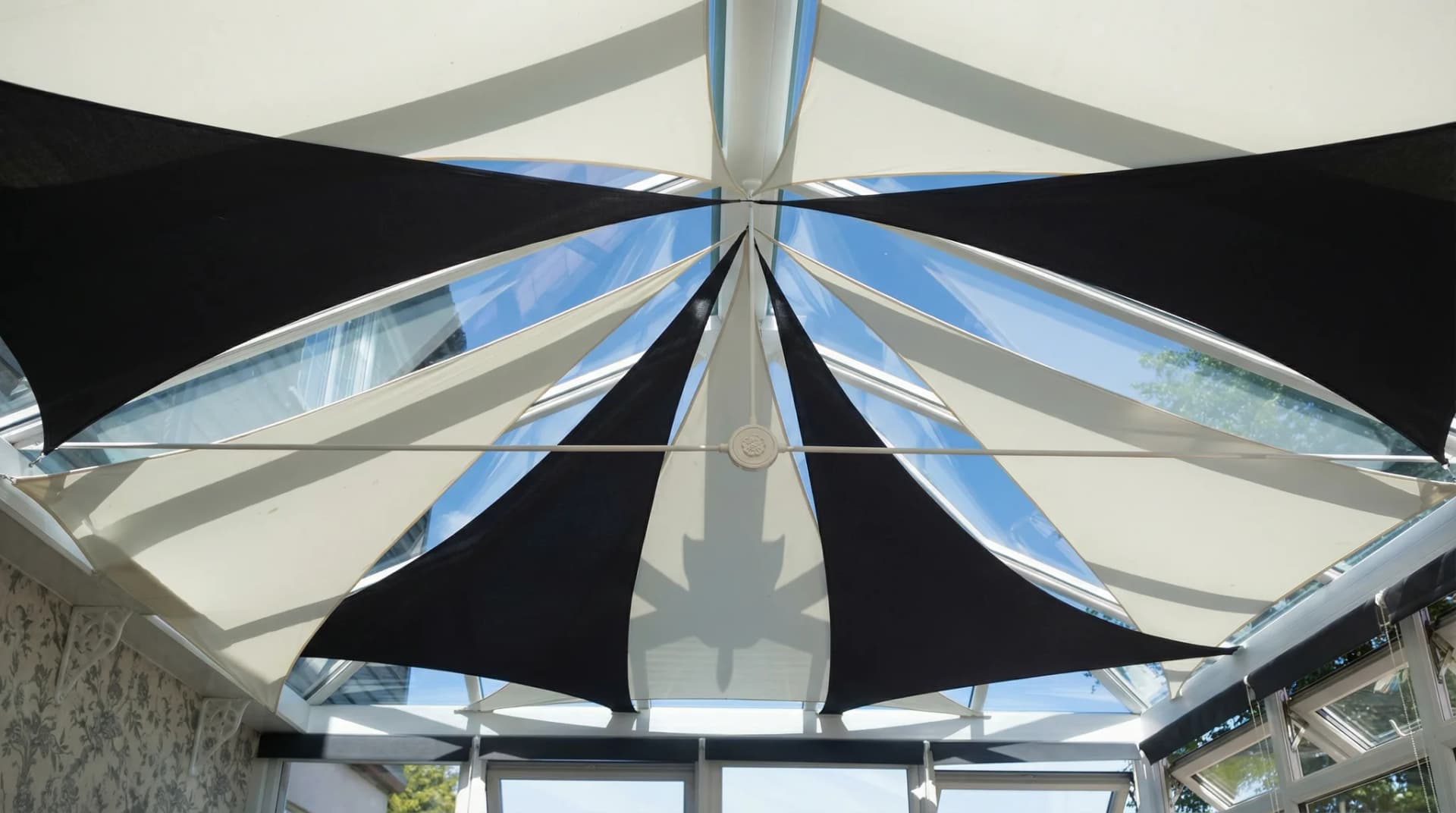 Invändigt solsegel under glastak med cirkulära ljusarmaturer